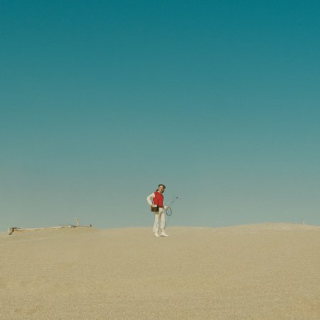 L'artista Azul tocant la guitarra envoltat de flors a la floristeria